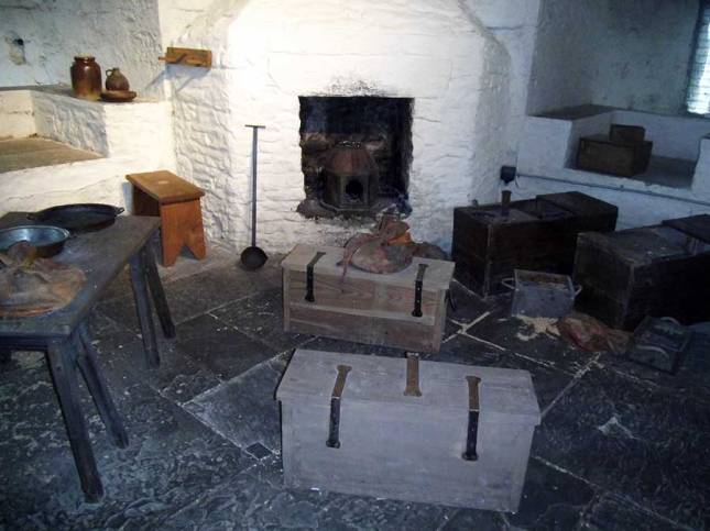 Chests and a fire inside a room in one of the round towers, with narrow windows