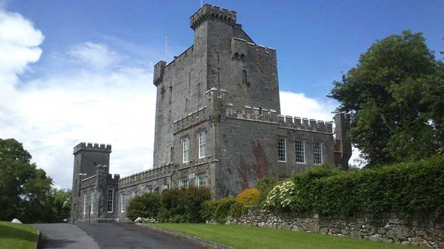 The front of Knappogue Castle with it's tall central tower surrounded by two-storey extension and courtyard.