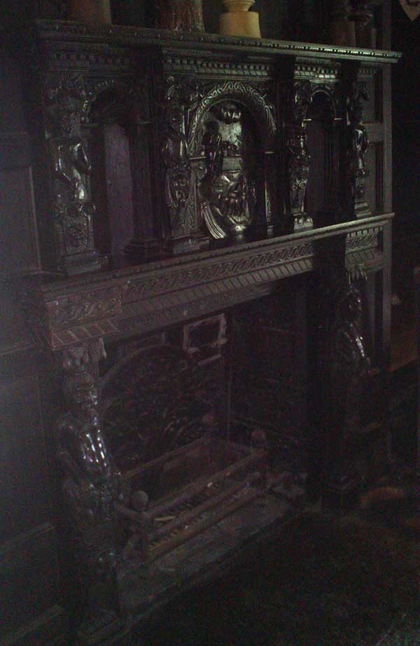 Very detailed wooden fireplace surround featuring carved people.
